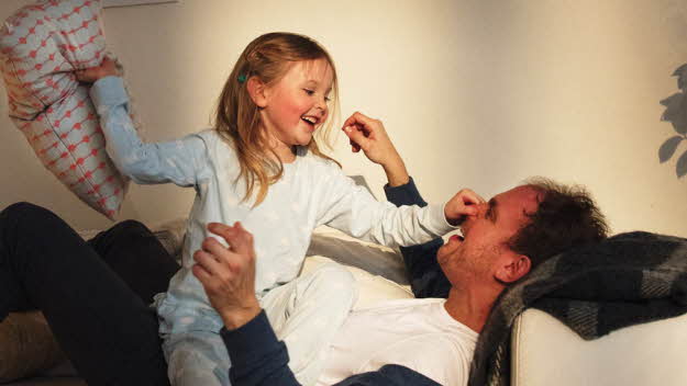 Kuddkrig i soffa med pappa och dotter.