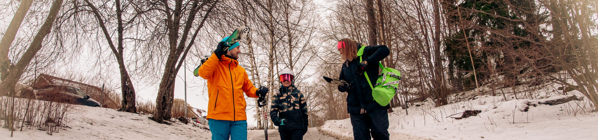 Familj med skidor på väg till backe