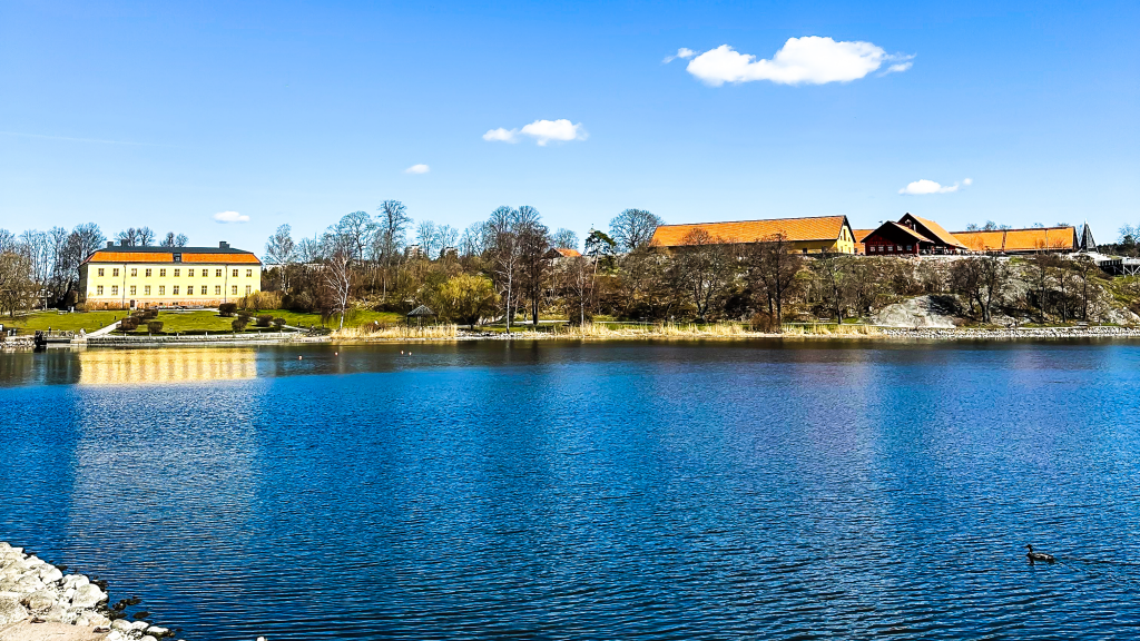 Vy över Edsviken. På bilden är en klarblå himmel, ett mörkblått vatten, Edsvik slott samt Stallbacken