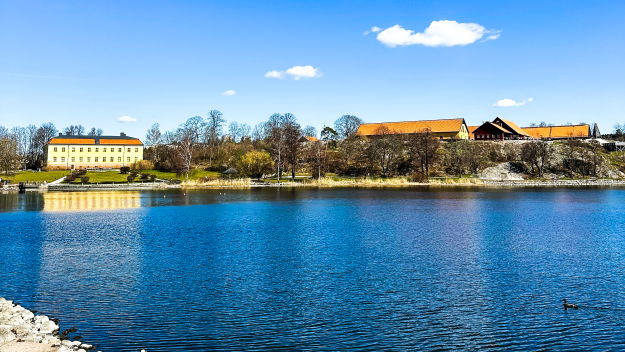 Vy över Edsviken. På bilden är en klarblå himmel, ett mörkblått vatten, Edsvik slott samt Stallbacken
