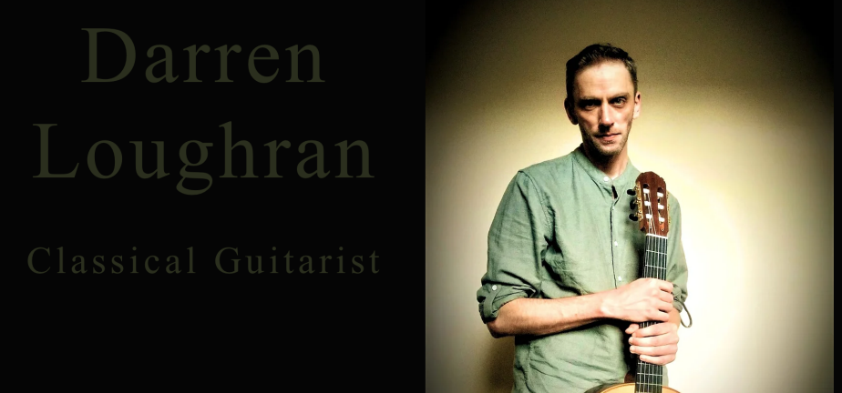 Porträttbild av Darren Loughran som står med en gitarr i handen.