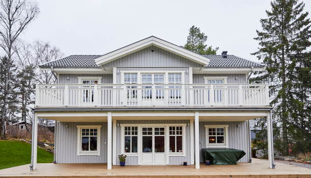 En fin, nybyggd trävilla med ljusgrå fasad. Villan har en stor altan och terrass.