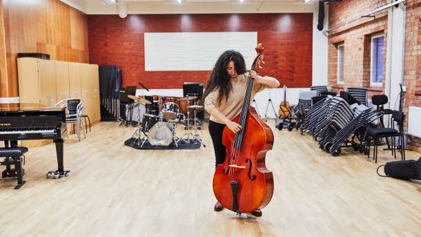Ungdom spelar cello i ett konsertlokal